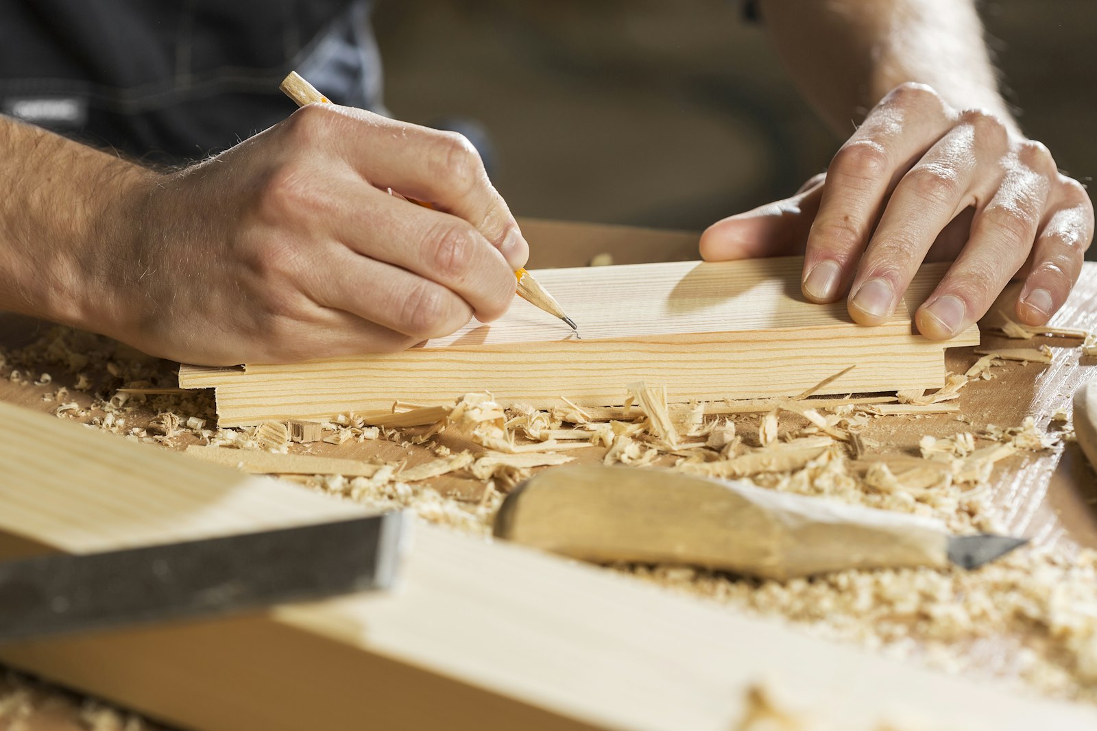 Carpenter marking a cut on lumber